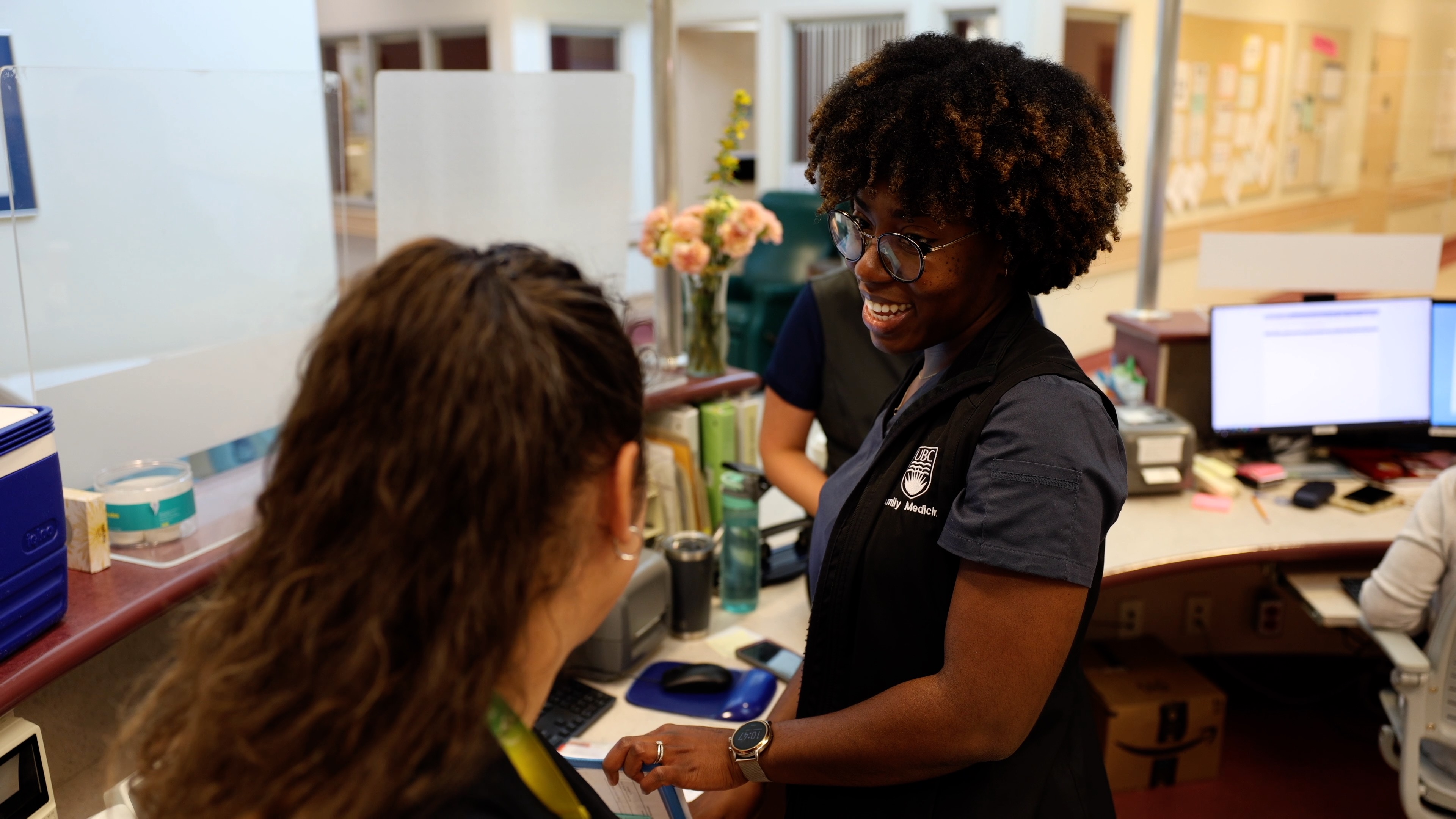 ""Nurse smiles while interacting with colleague