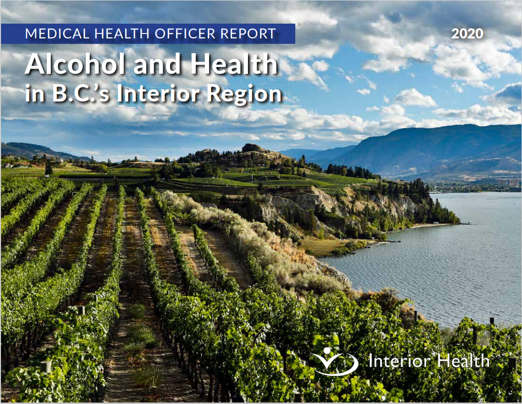 Green vineyards in full bloom next to a lake and mountains on a sunny day