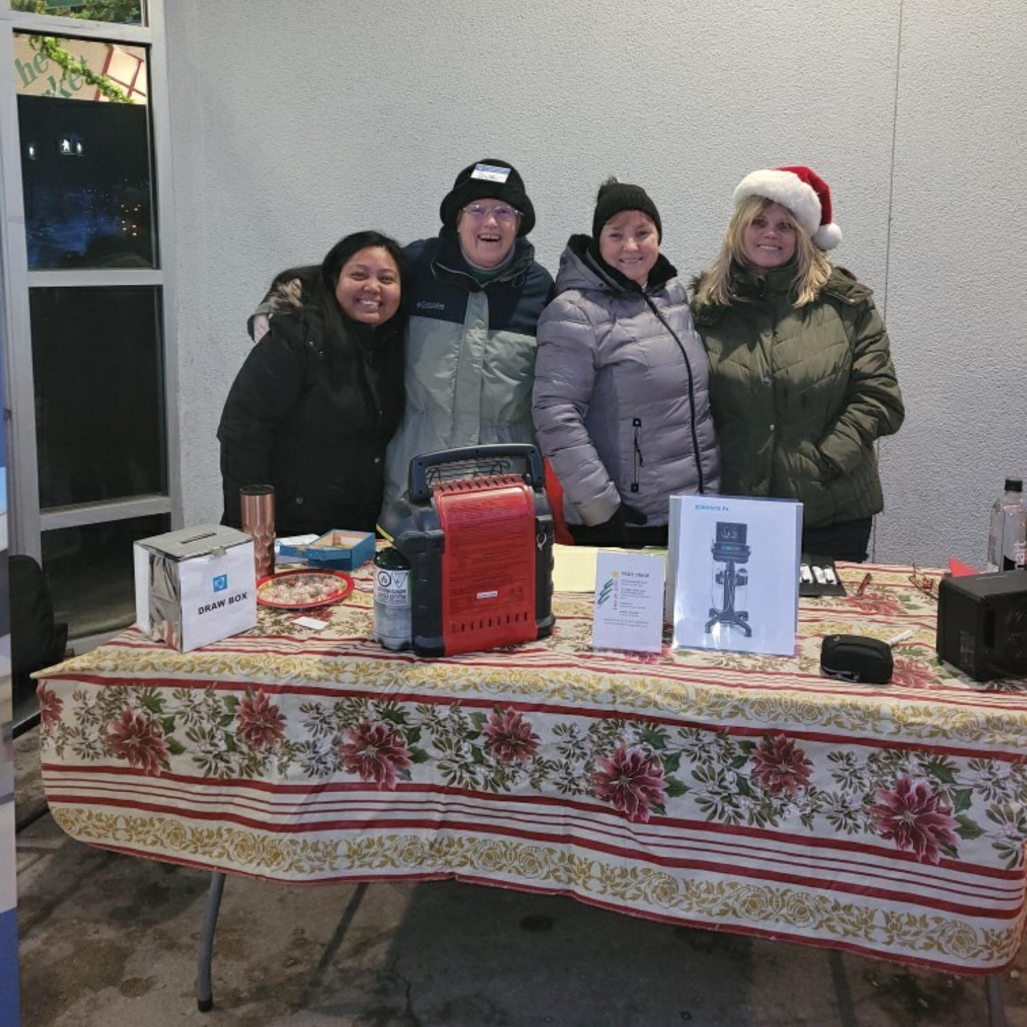 a group of volunteers collecting donations outside a grocery store wearing santa hats.