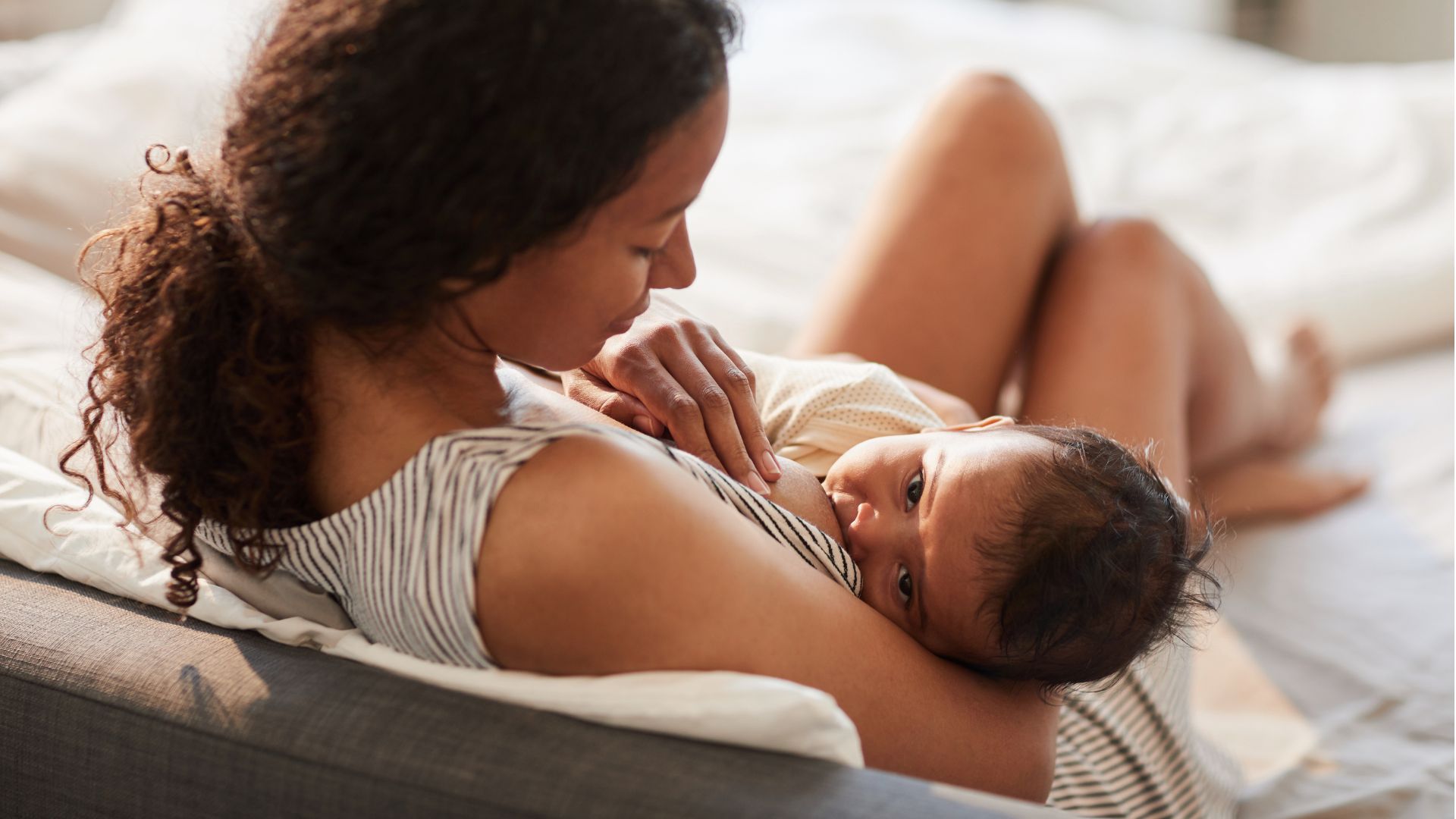 A parent breastfeeding an infant 