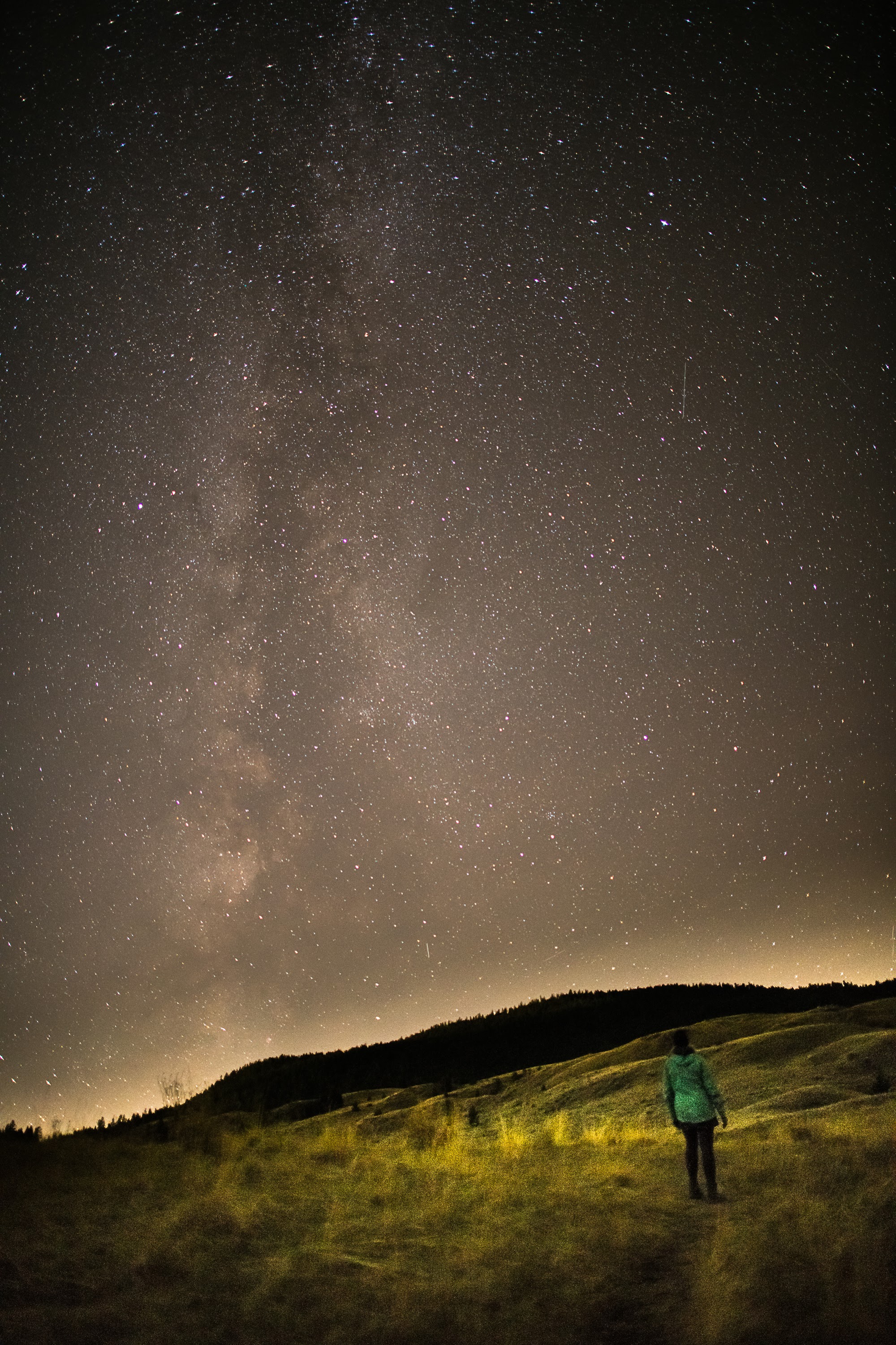 A woman sitting under the stars at night.