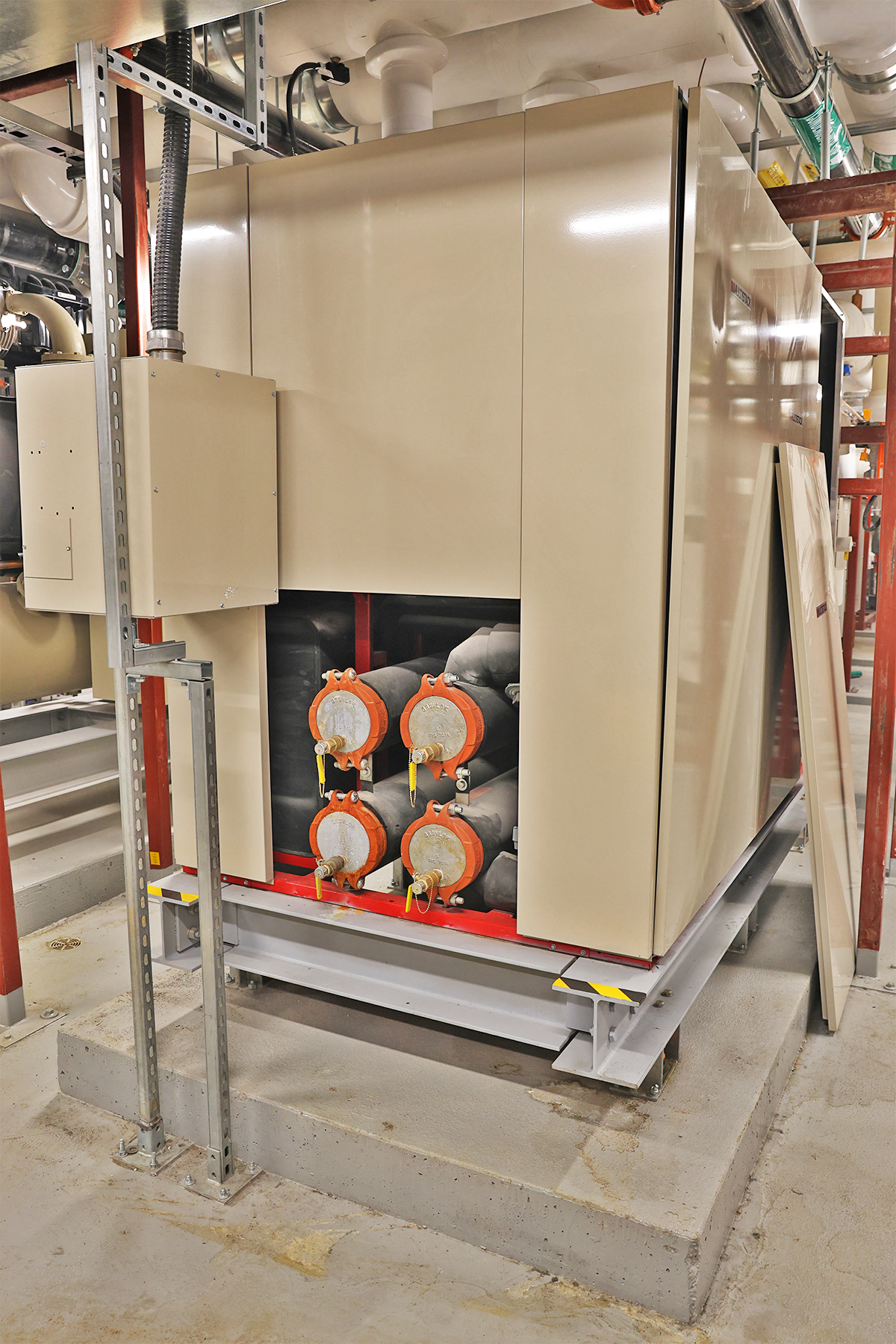 A large heat recovery unit with beige metal sides and orange tubes. 