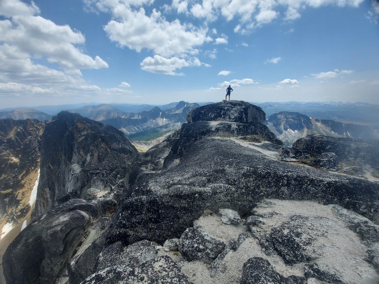 A person in the distance standing on top of a mountain.