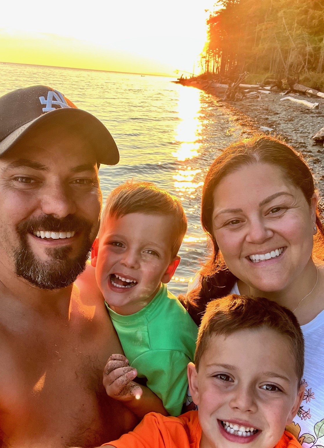 A family stands to take a picture by the beach