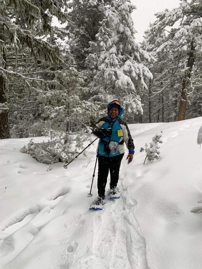 A woman snow shoeing in the forest.