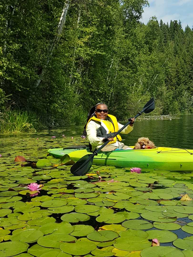 A woman in a kayak with a dog.