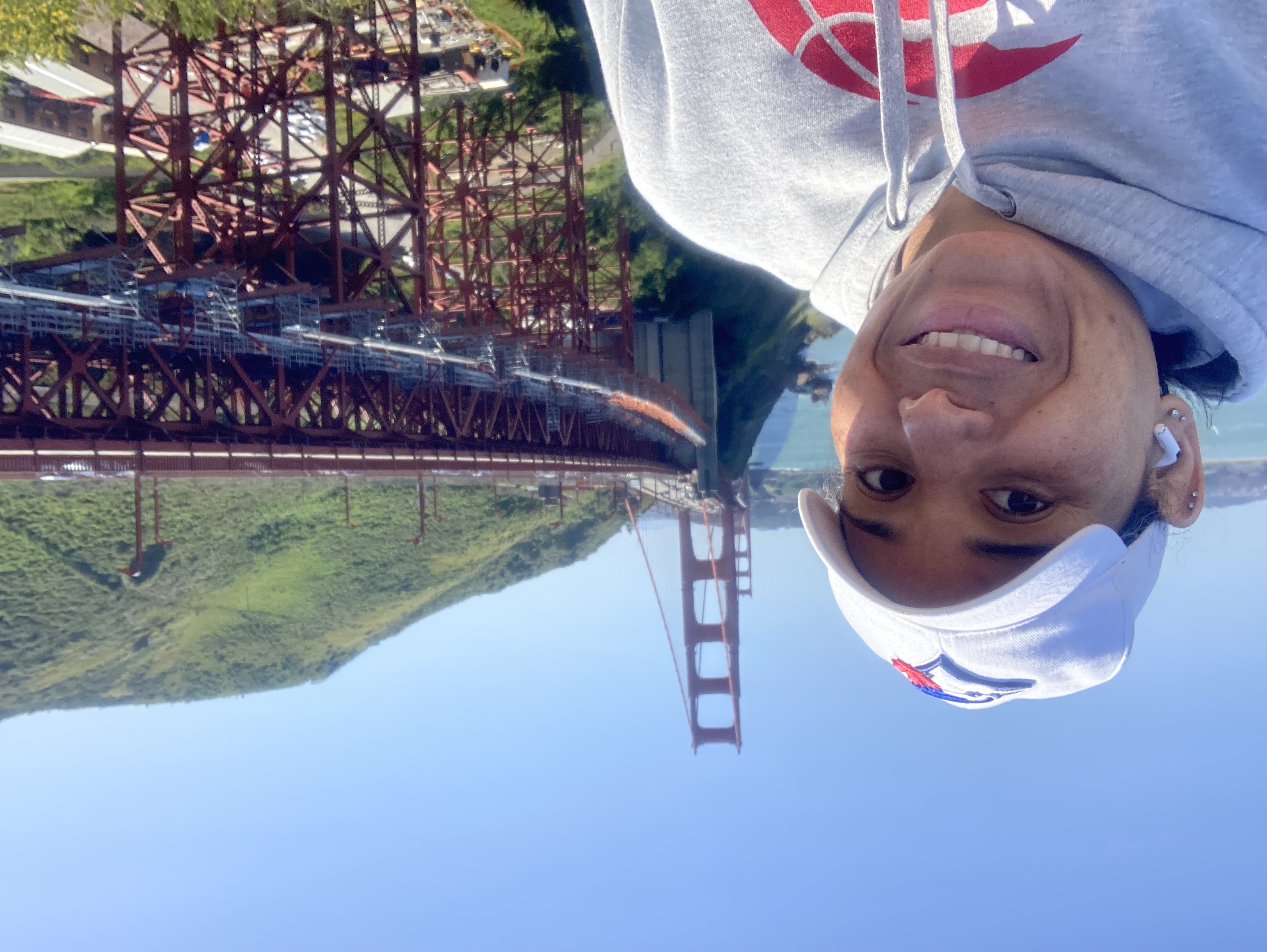 A Black woman smiling with the Golden Gate Bridge behind her