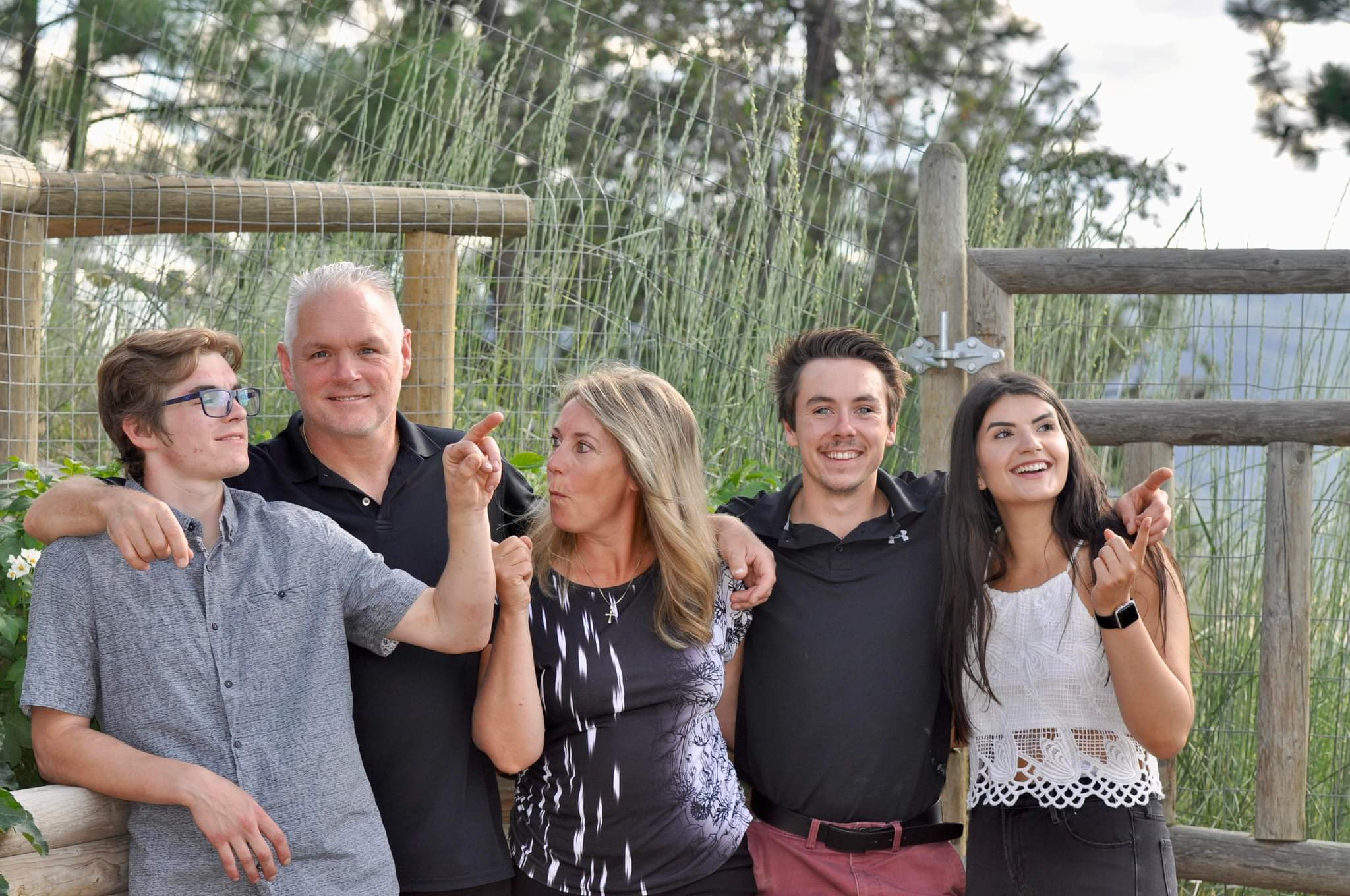 Five people standing in a row, looking in different directions