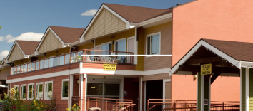 An orange two-storey building with three yellow gables and a large deck