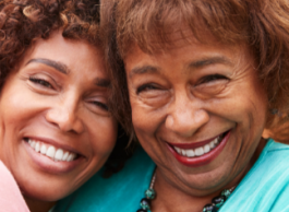 Two women smile while posing for a picture.