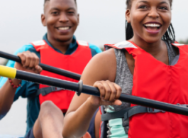 Two people in a canoe wearing personal flotation devices.