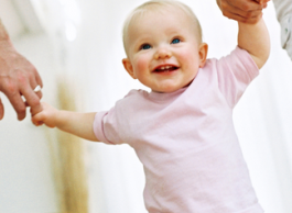 Parents hold their child's hand.