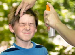 Mother applying bug spray or sunscreen to her son.