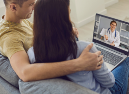 Two people attending a virtual appointment using their laptop.