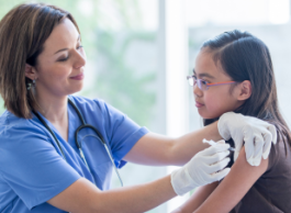 A nurse gives a vaccine to a child.