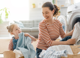 A young girl and her mother do laundry