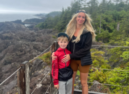 A blonde woman and her young son looking at the scenery at the top of a mountain 