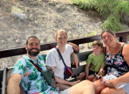 From left to right, a man, women, child and another woman with on a train